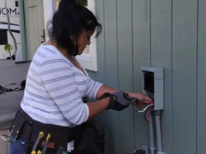 Licensed electrician wiring an exterior subpanel in Phelps